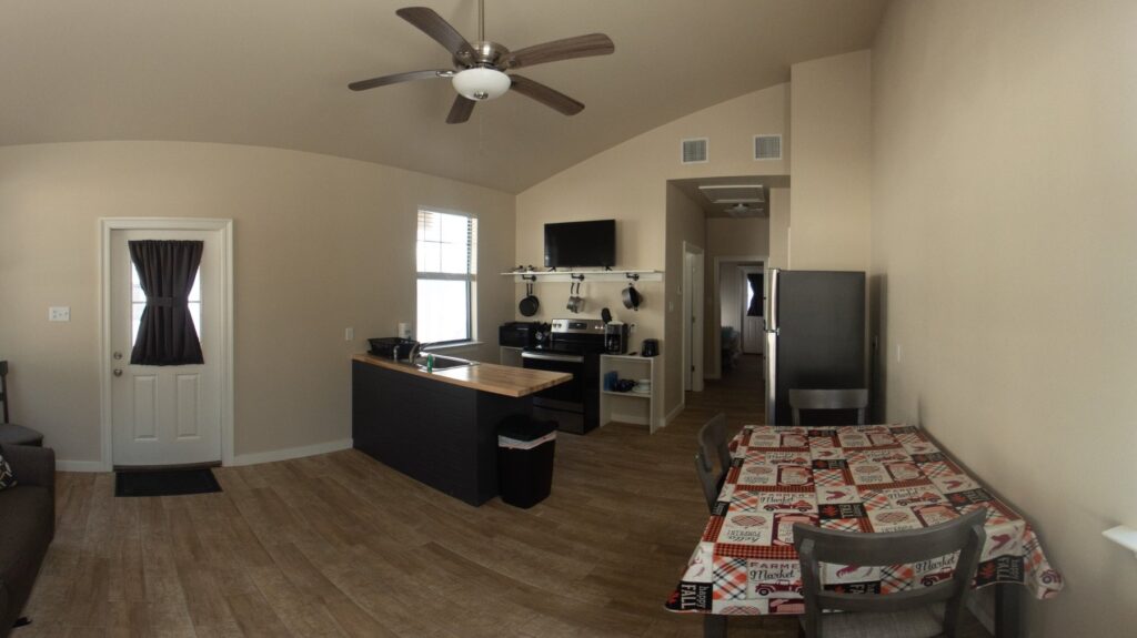 Furnished interior of a Fireside cabin with full kitchen, dining table, sofa, and smart TV